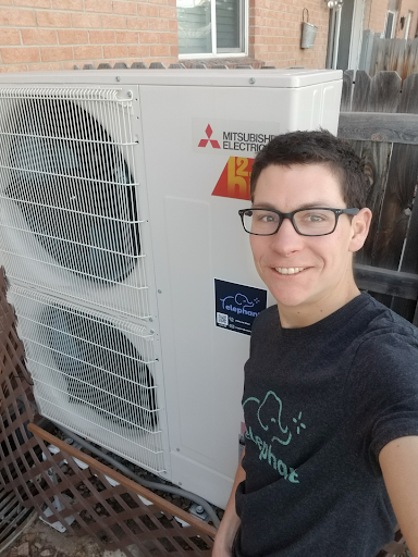 A satisfied customer next to their newly-installed heat pump solution